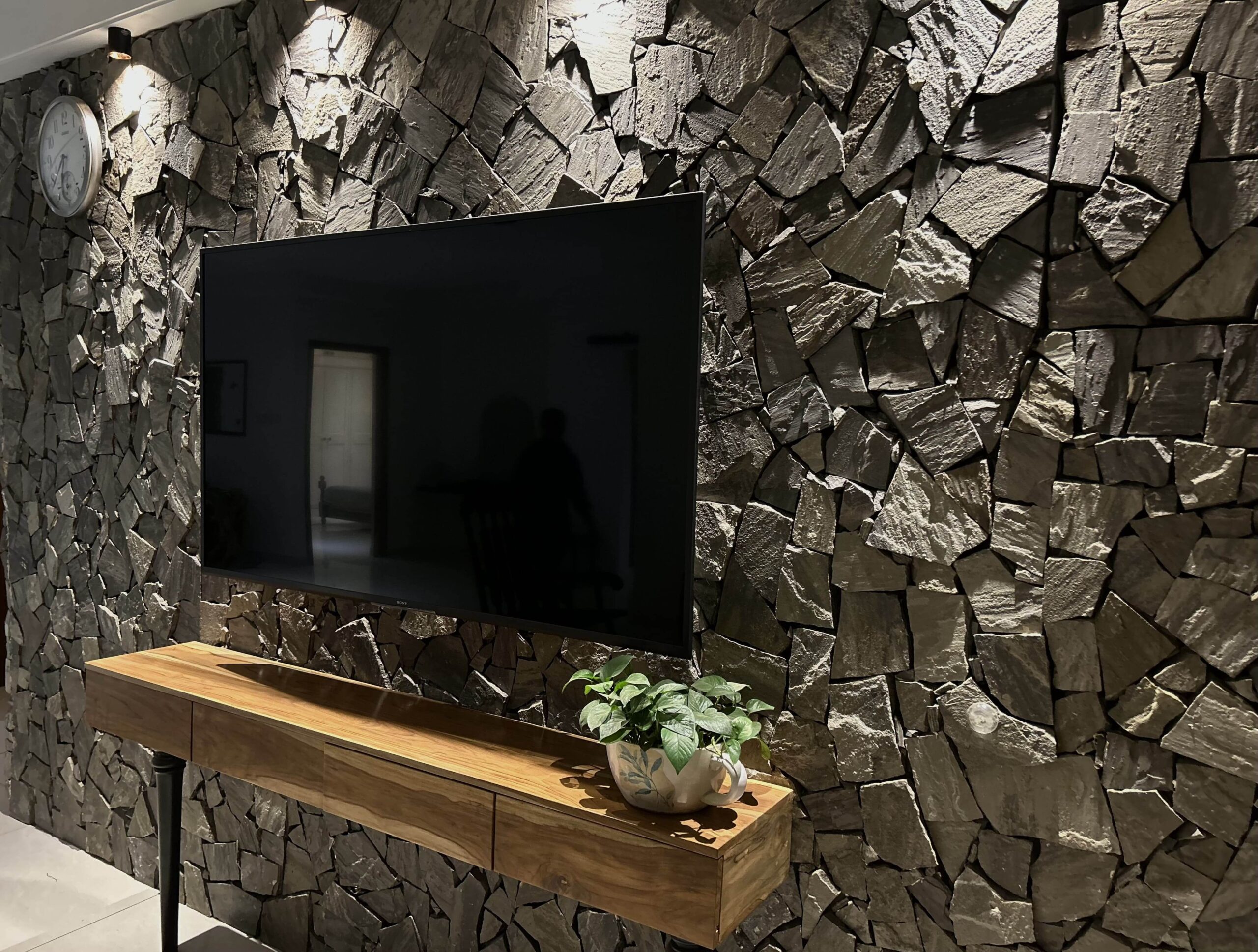 Lounge corner with green velvet chairs and wooden desk against sheer curtains and greenery, black-inlay terrazzo, Hyderabad