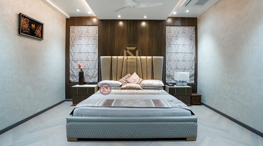 Master bedroom with tall upholstered headboard, walnut wood panelling and herringbone flooring, Hyderabad