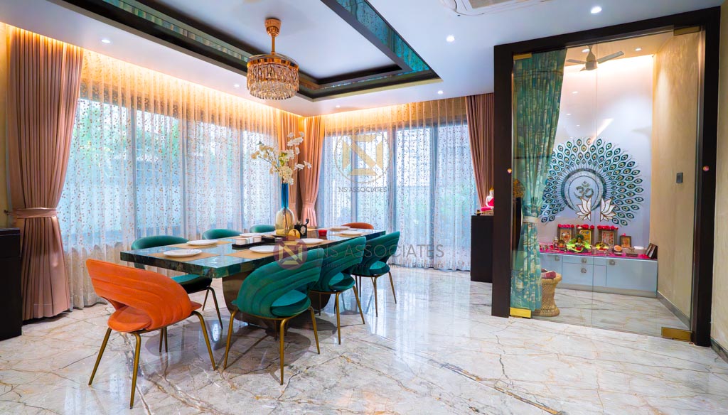 Dining room with marble floor, green velvet and orange chairs, crystal chandelier and pooja unit, Hyderabad