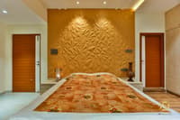 Bedroom with sculpted gold 3D-textured feature wall, twin teak doors and warm cove lighting, Hyderabad home