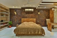 Bedroom with brown stone feature wall, wooden bed, hanging pendant lights and recessed niche shelving
