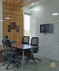 Office cabin featuring a timber-panelled feature wall, abstract framed art, dark desk and wall-mounted TV, Hyderabad
