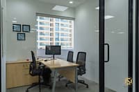 Private office cabin with light-wood desk, black mesh chairs, framed certificates and a city-view window, Hyderabad