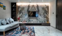 Living room featuring a book-matched marble TV wall, white sofa and geometric rug, Hyderabad