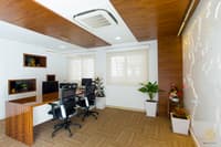Compact office cabin with wood-slat ceiling, twin workstations, planters and a textured map wall, Hyderabad