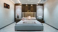 Bedroom with tall upholstered headboard, wood-panelled feature wall, twin nightstands and herringbone floor, Hyderabad