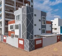 Three-storey home exterior with grey textured facade, red accent panels and white trim, Hyderabad
