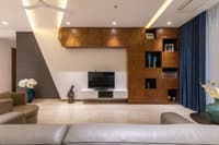Living room with parquet wood feature wall, grey brick panel, blue drapes and floating TV unit, Hyderabad