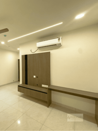 Wood TV panel with floating console and side desk, split AC and cove-lit ceiling in a bedroom, Hyderabad