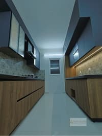 Parallel galley kitchen in navy and warm woodgrain with patterned backsplash and black counters, Hyderabad apartment