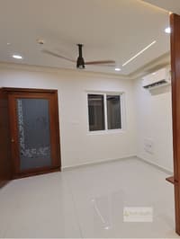 Empty bedroom with laser-cut jali wood door panel, split AC and linear-lit false ceiling, Hyderabad apartment