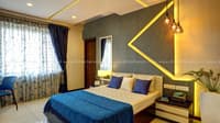 Bedroom with grey LED chevron feature wall, blue bedding, floral sheers and corner study desk by the window, Hyderabad
