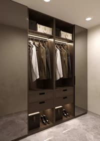 Walk-in closet in dark wood with backlit hanging rails, drawers and open shoe storage on marble floor, Hyderabad