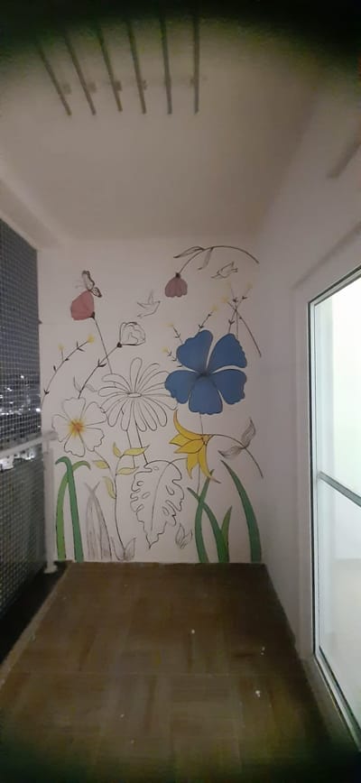 Hand-painted floral mural on a balcony wall in Hyderabad with blue, pink and yellow wildflowers, butterflies and green grass