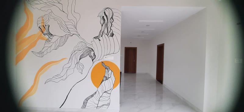 Hand-painted abstract line-art mural in fine black ink with orange sun accents on a hallway feature wall, Hyderabad villa