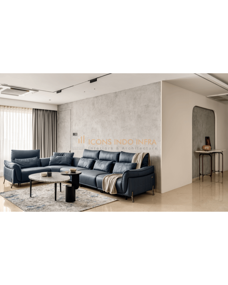 Living room in Hyderabad with navy leather L-shaped sofa, concrete-finish accent wall and nested marble coffee tables