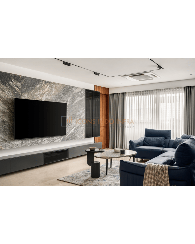 Living room in Hyderabad with marble TV wall, fluted wood panel, navy sofas and a stone coffee table on a grey rug