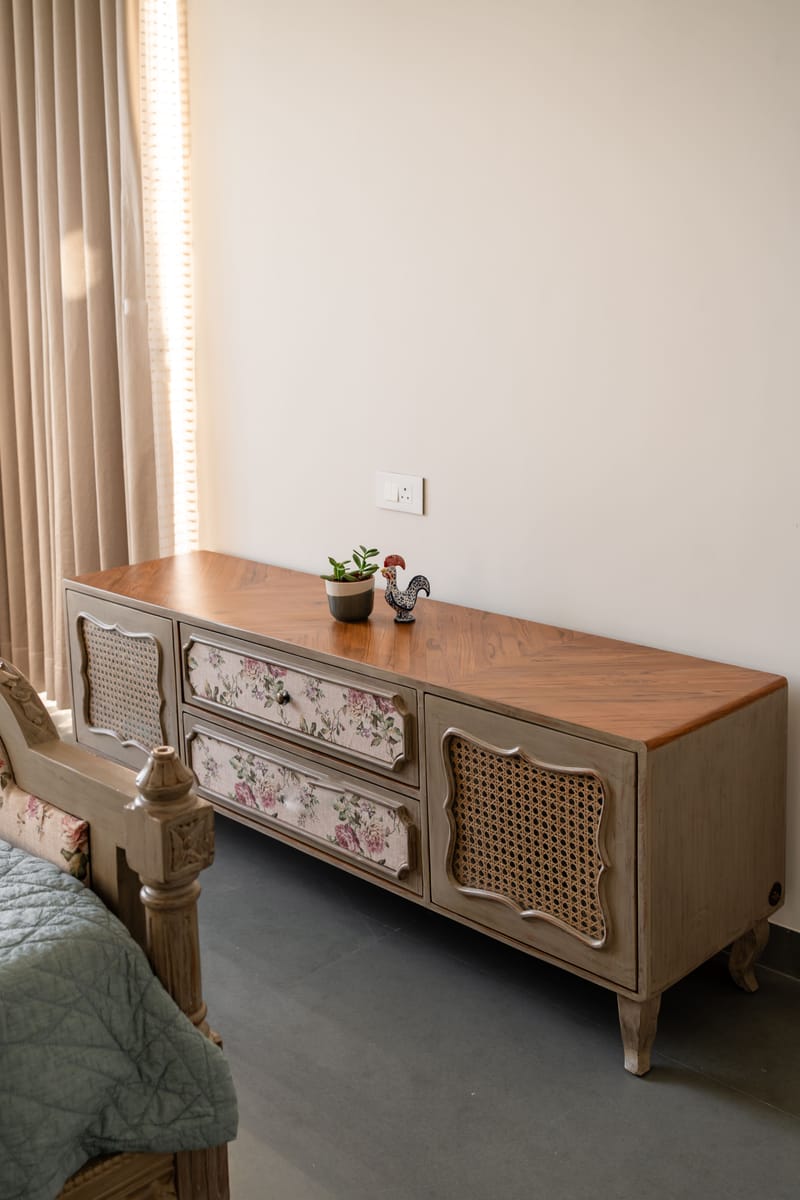 Bedroom media console in Hyderabad, French-style wood unit with floral-print drawers and woven cane door panels