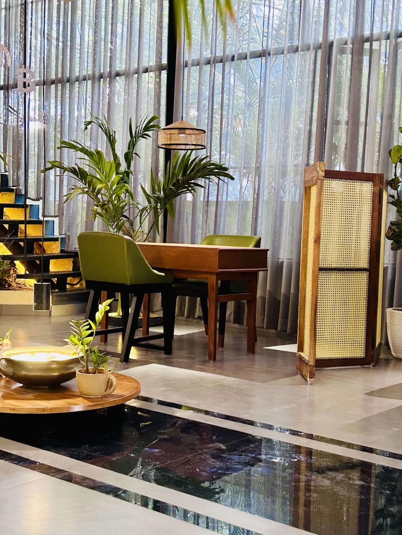 Living room TV wall in dark stacked-stone cladding with a live-edge wooden floating console and money plant, Hyderabad