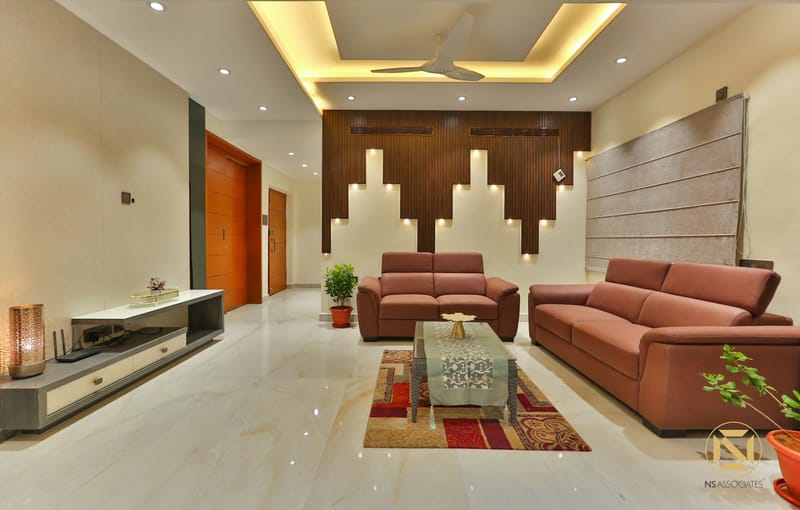 Living room with twin rust leather sofas, backlit wood-slat feature wall and patterned rug on glossy marble floor