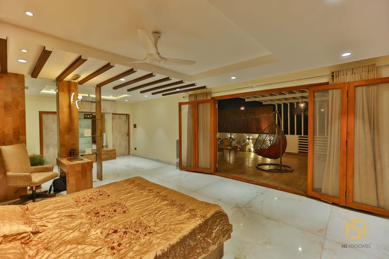 Master bedroom with wooden-slat false ceiling, gold satin bedspread and marble floor opening to a terrace, Hyderabad