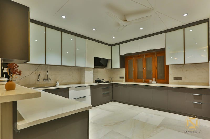 U-shaped modular kitchen with glossy grey cabinets, frosted-glass uppers, marble backsplash and wood pantry, Hyderabad