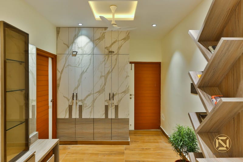 Bedroom wardrobe in book-matched marble laminate with teak doors and angular wooden display shelves, Hyderabad