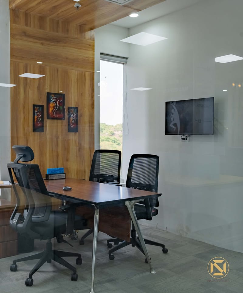 Office cabin featuring a timber-panelled feature wall, abstract framed art, dark desk and wall-mounted TV, Hyderabad