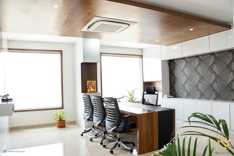 Manager cabin with wooden ceiling, conference table, ergonomic chairs and textured grey accent wall, Hyderabad office