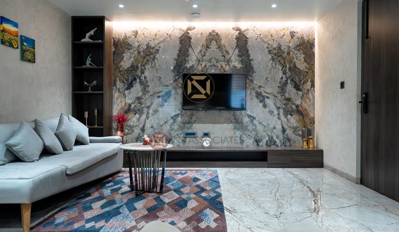 Living room featuring a book-matched marble TV wall, white sofa and geometric rug, Hyderabad