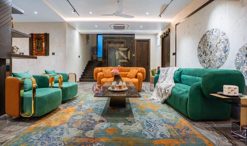 Family lounge with emerald and orange velvet sofas over a patterned blue rug, Hyderabad
