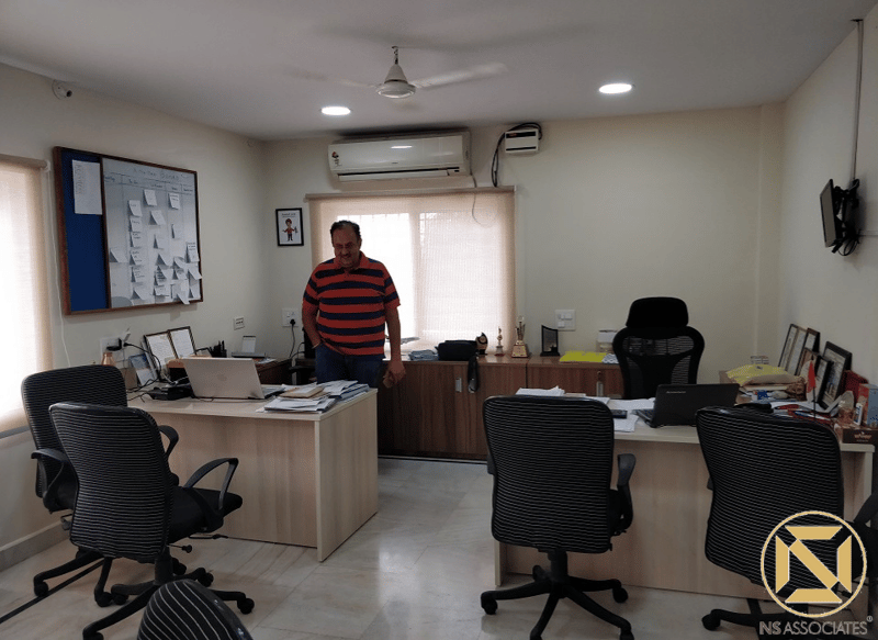 Private office cabin with wood-laminate desks, pinboard and black mesh chairs under recessed lights, Hyderabad