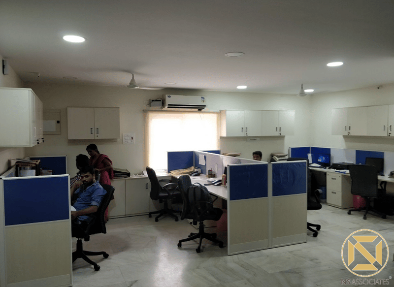 Open-plan office with blue partitioned workstations and recessed downlights, Hyderabad commercial fit-out