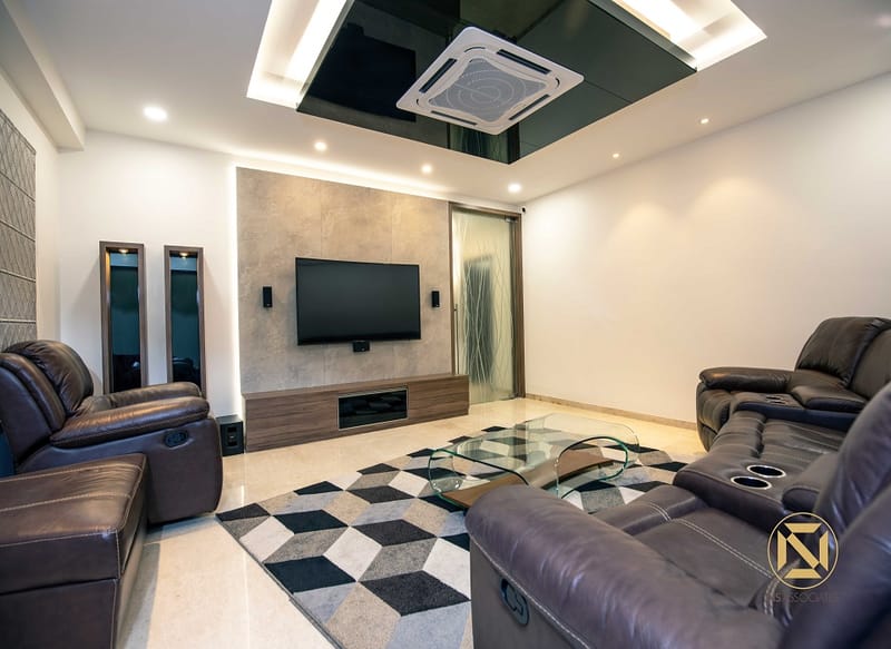 Living lounge with brown leather recliners, geometric black-and-white rug, wall-mounted TV on stone-tile feature wall, Hyderabad