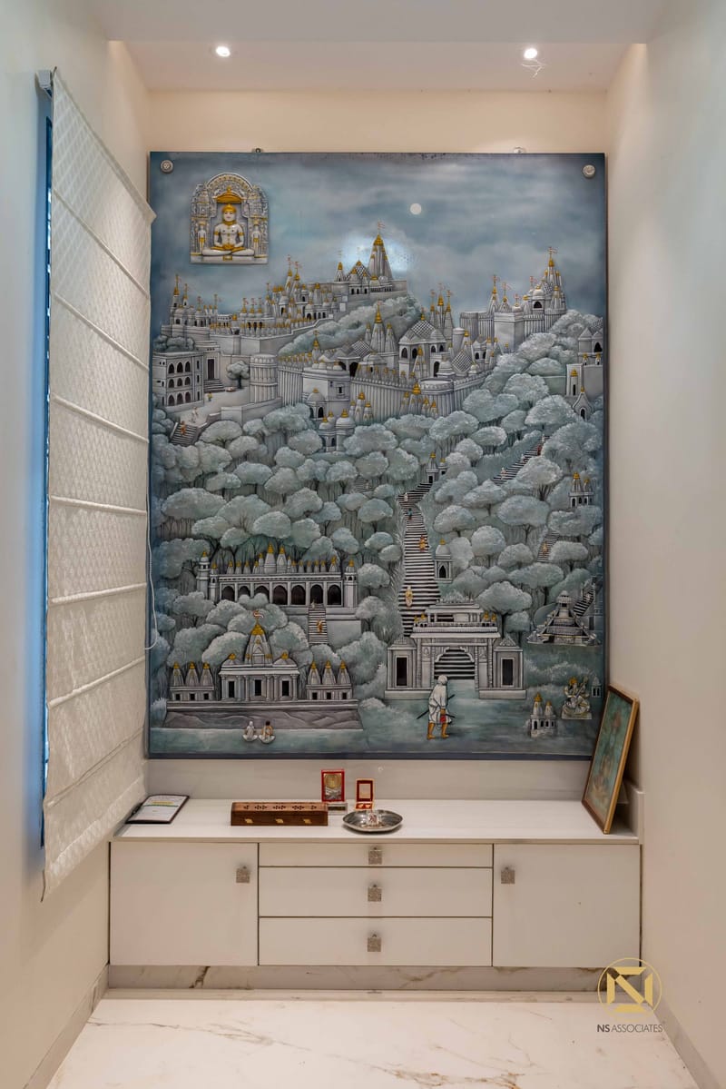 Pooja room with large hand-painted temple-and-hills mural in blues and silver above a white storage cabinet, Hyderabad