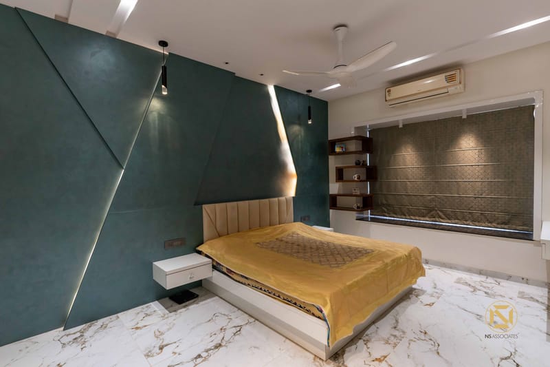 Bedroom with teal textured accent wall, upholstered bed in gold throw and Calacatta marble floor, Hyderabad