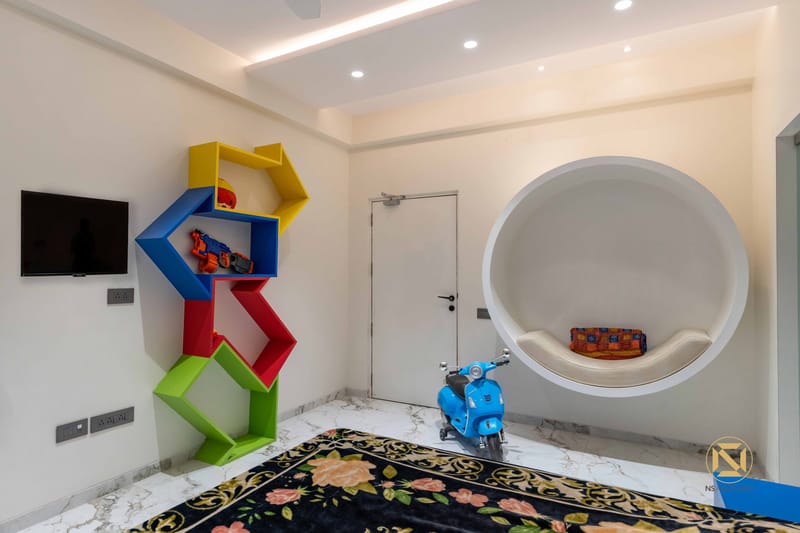 Kids' room with bright geometric bookshelf, round cushioned reading nook and floral rug, Hyderabad full home