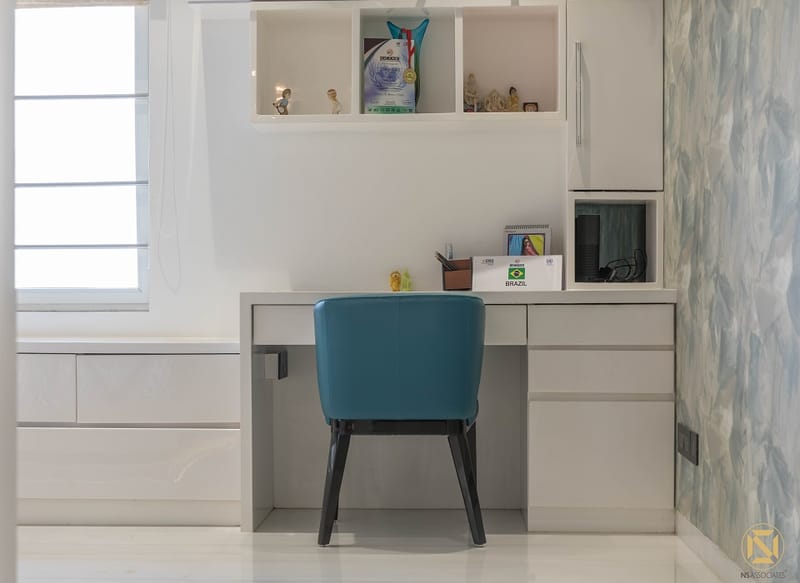 White study desk with overhead storage cubbies, teal upholstered chair and marbled blue accent wall, Hyderabad