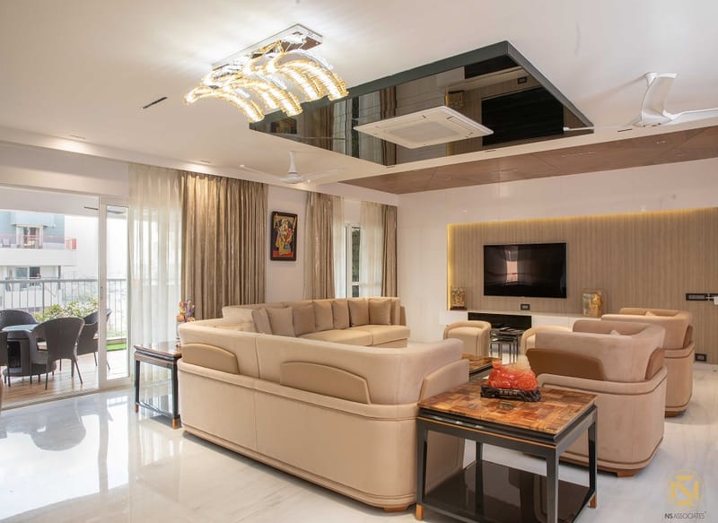 Spacious living room in Hyderabad with cream upholstered sofas, marble floor, chandelier and balcony dining nook