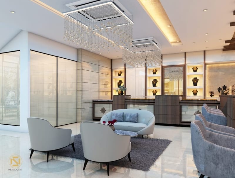 Jewellery store lounge with twin crystal chandeliers, backlit gold display cabinets and blue accent chairs, Hyderabad