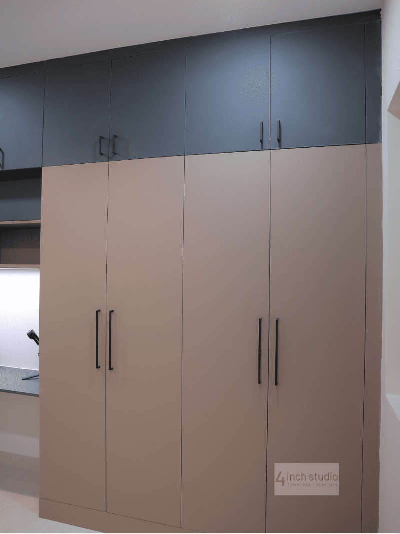 Floor-to-ceiling bedroom wardrobe with taupe shutters and navy-blue upper cabinets in a 3BHK apartment, Hyderabad