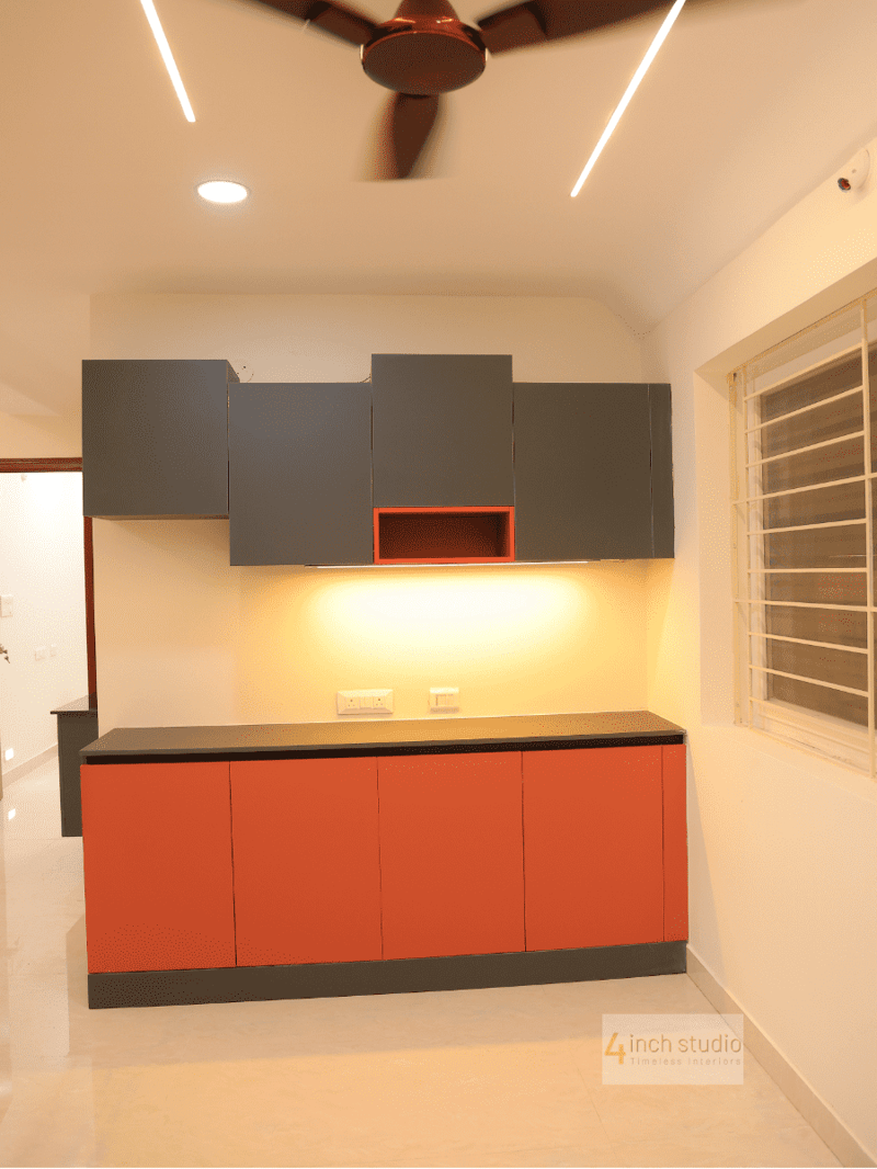 Modular crockery unit with grey overhead cabinets and burnt-orange base units under cove lighting, Hyderabad