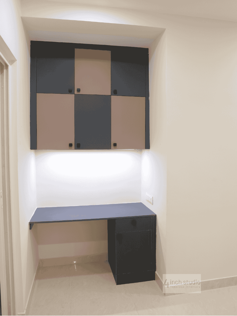 Compact study nook with charcoal-and-beige checkerboard wall cabinet and slim blue desk, Hyderabad apartment