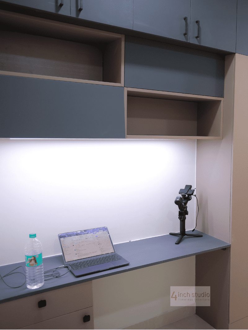 Home study desk in blue laminate with grey-and-beige overhead storage cabinets and under-shelf lighting, Hyderabad apartment