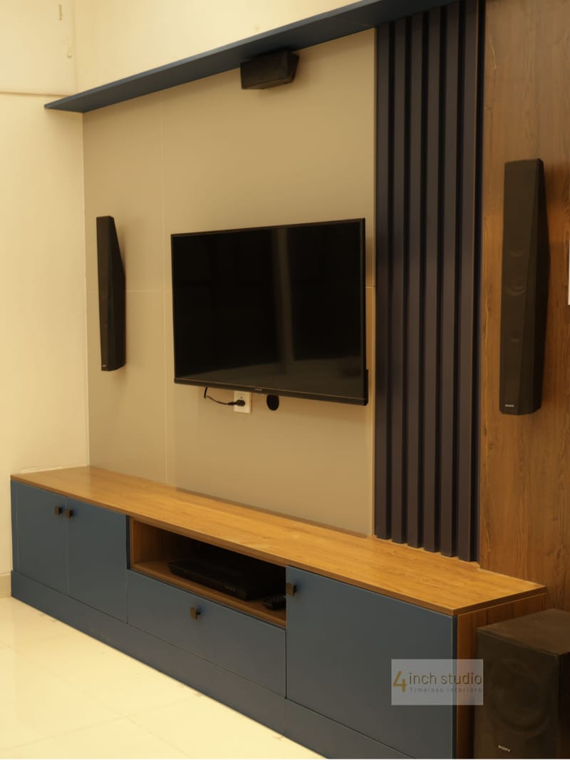 TV unit with wall-mounted screen, charcoal fluted panel, woodgrain accent and navy floating console, Hyderabad