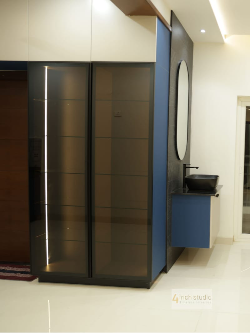 Foyer with frosted-glass sliding wardrobe, navy panel and wall-mounted vanity with oval mirror, Hyderabad