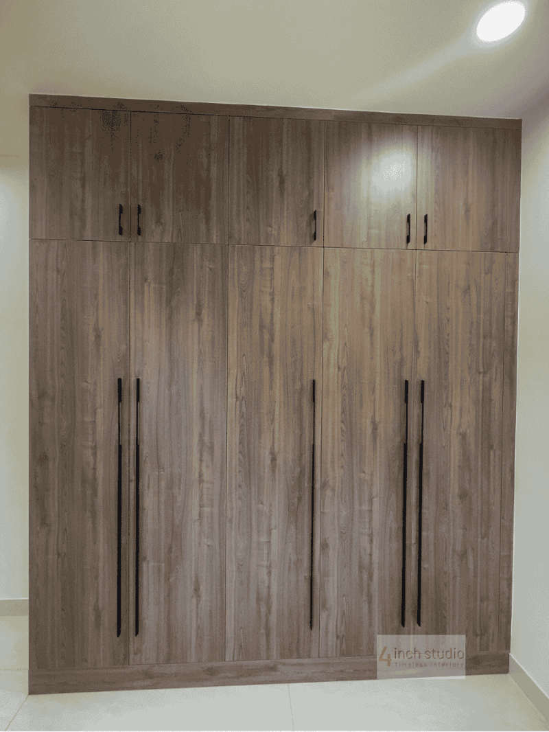 Full-height six-door wardrobe in grey-toned wood with slim black handles against a cream wall, Hyderabad