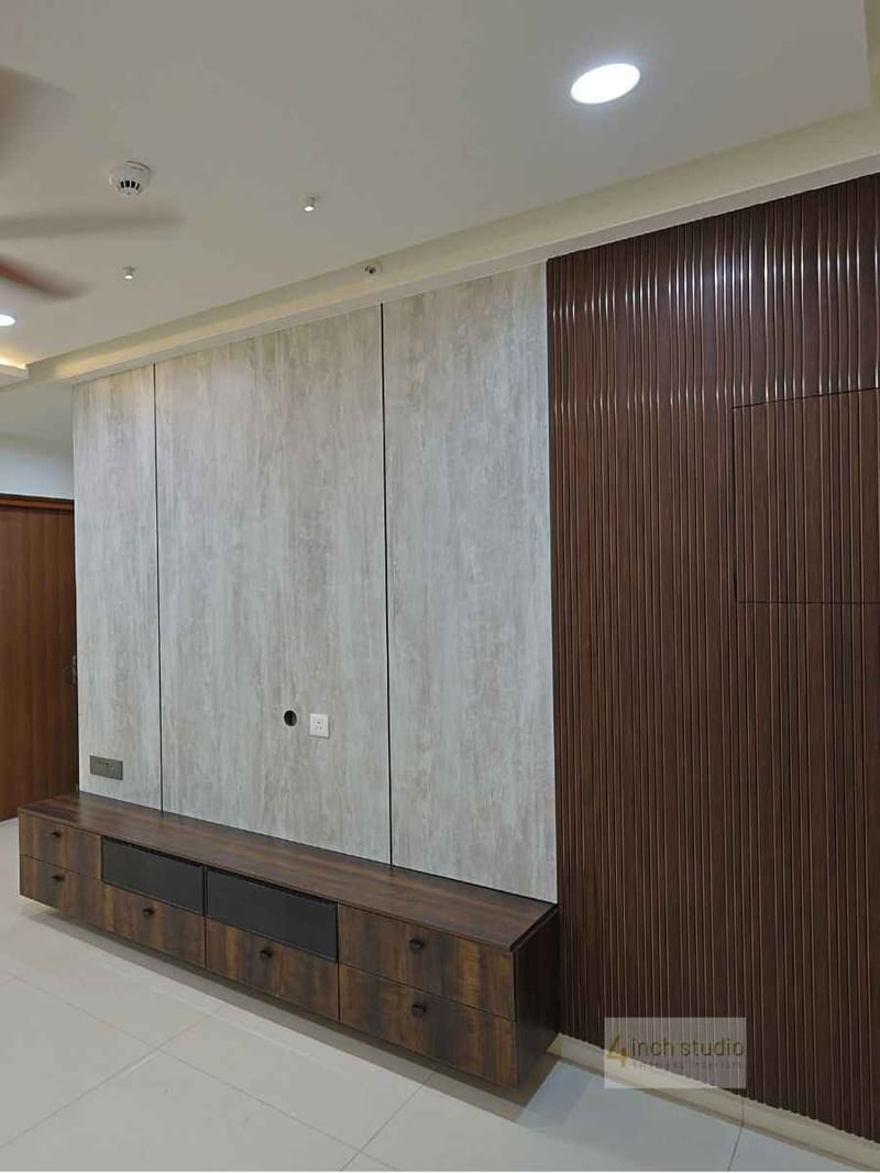 TV wall with fluted dark-wood panel, travertine-look stone cladding and low wooden console, Hyderabad