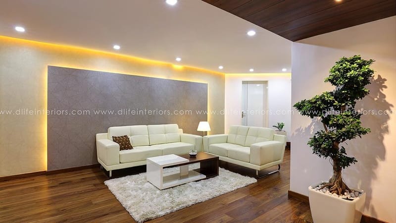 Family living room in Hyderabad with white sectional, swivel chairs, wall-mounted TV and roller blinds on wood floor