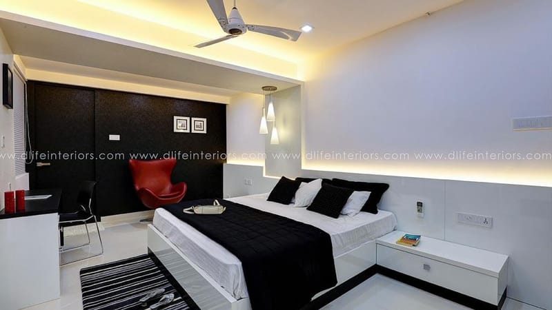 Bedroom in Hyderabad with timber-panel accent wall, beige bedspread, study desk and roller blind by the window